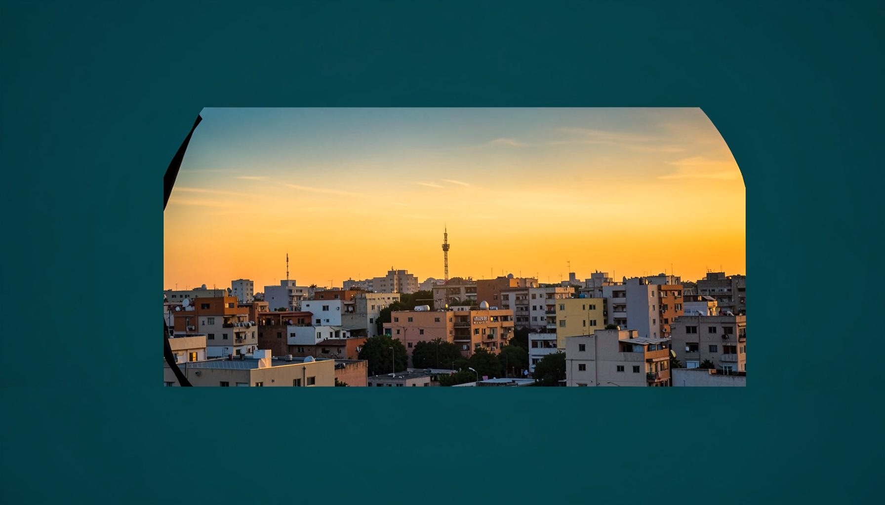 مشهد بانورامي لمدينة ساجر عند الغروب، سماء دافئة بألوان برتقالية وذهبية تمتد فوق أبنية منخفضة ومئذنة في الأفق